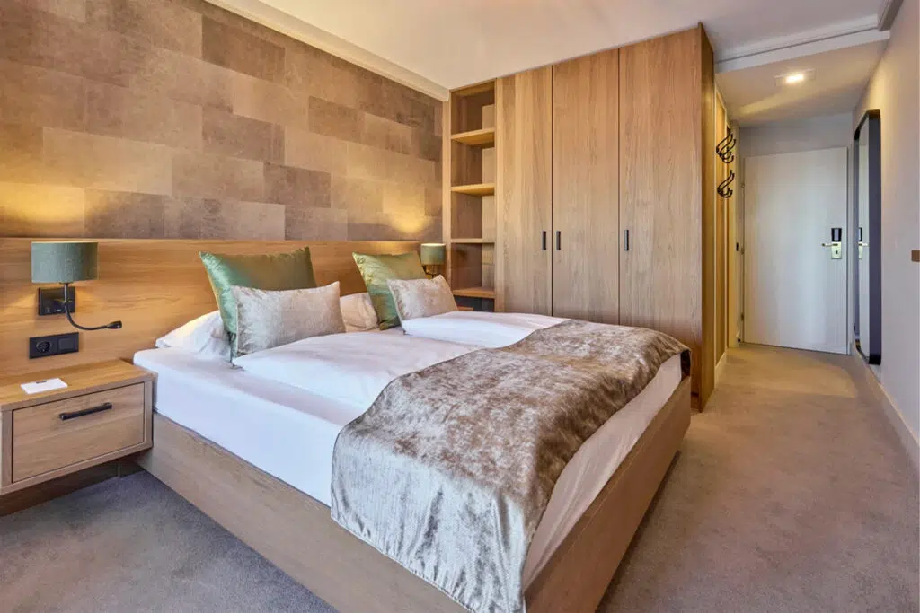 Doppelbett mit Eichenkopfteil, grünen Leuchtenschirmen und Samtplaid, Aldiana Club Schlanitzen Alm