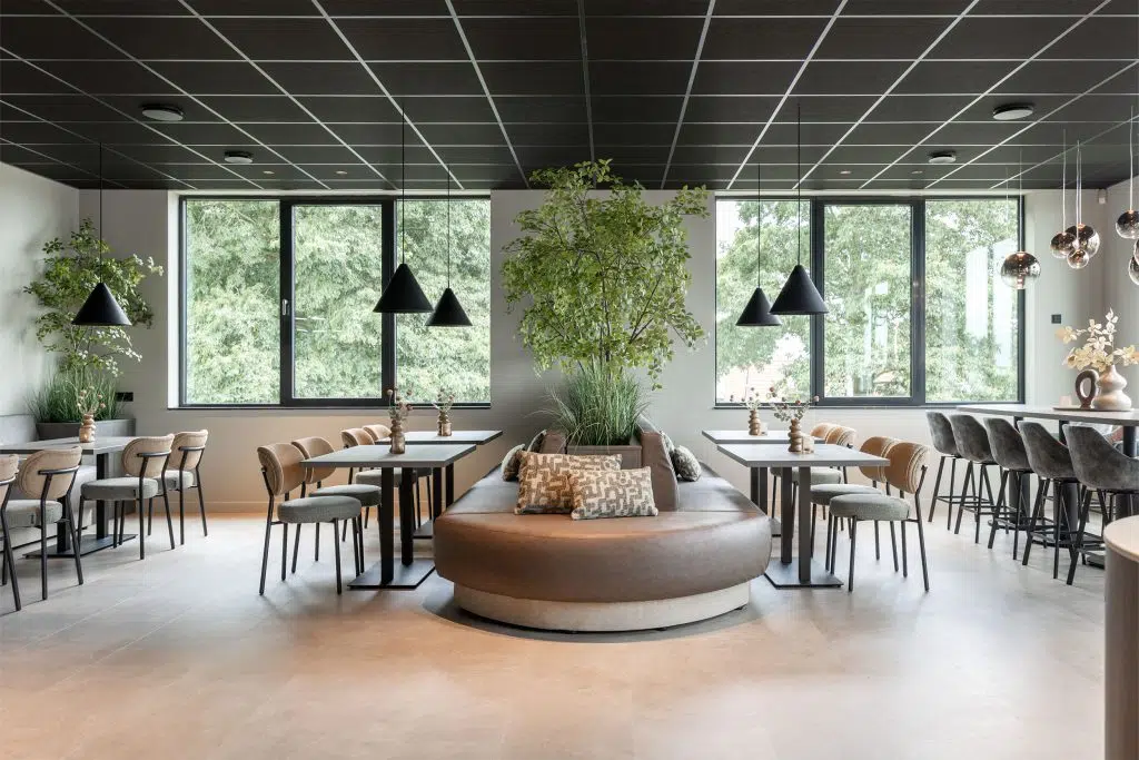 Betriebsrestaurant mit runder Lederbank, Bistrotischen und schwarzen Kegelleuchten